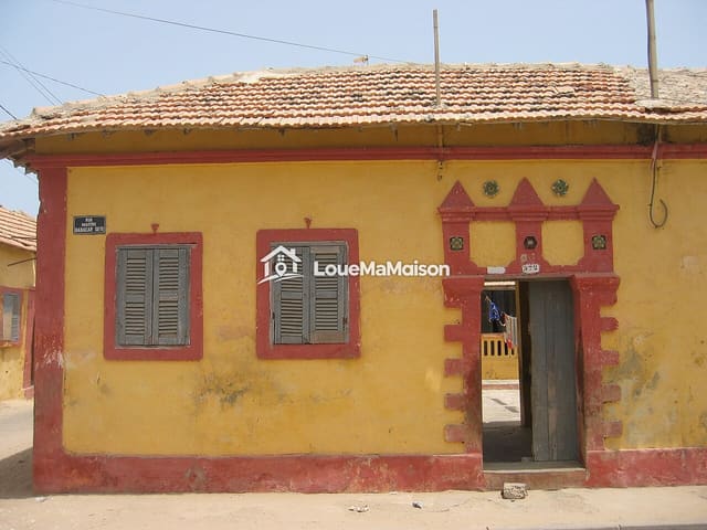 Maison jaune de plain-pied à Dieuppeul