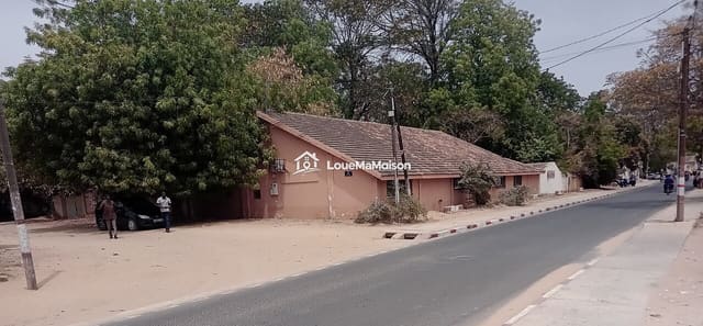Maison rose au toit de tuiles à Bonabéri