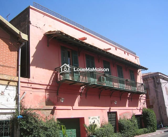 Maison rose à étage avec balcon à Gueule Tapée