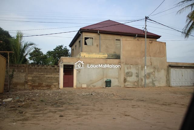 Maison à étage au toit rouge à Baguida